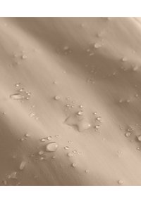 Tissu imperméable beige avec des gouttes d'eau, présentant une texture lisse et un léger éclat. La surface semble durable et flexible.
