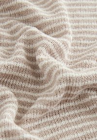 Knitted fabric with alternating beige and off-white stripes, featuring a soft texture and a slightly wavy appearance.