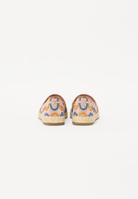 Színes espadrille cipők mintás textil felsőrésszel rózsaszín, narancssárga és kék színben; juta kötél talppal és barna bőr díszítéssel.