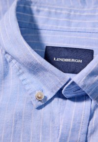 Lichtblauw gestreepte shirt met kraag van linnen textuur, met een button-down kraag en een zichtbaar merklabel: "Lindbergh."