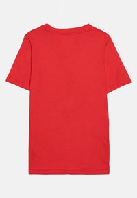 Camiseta de algodón roja con mangas cortas, escote redondo y una textura suave. Presenta un diseño liso sin patrones ni acentos.