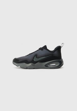 Sort og mørkegrå Nike træningssko med synlig luftpolstret sål og tekstureret overdel, vist i sideprofil på ensartet lys baggrund.