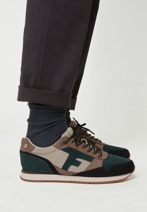 Sneaker multicolori con un mix di suede verde, marrone e beige. Presentano una suola in gomma, design con lacci e un accento del logo sul lato.