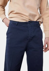 Chinos in cotone blu navy con design a gamba dritta, dotati di zip e chiusura con bottone, tasche frontali e finitura testurizzata.