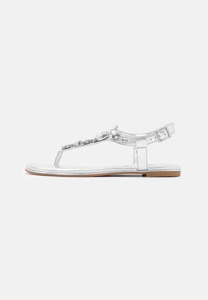 Silver metallic sandal featuring a toe post, adjustable ankle strap, embellishments along the upper, and a flat sole with brown accents.