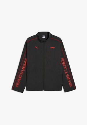 Czarna kurtka zapinana na zamek z czerwonymi logo Puma i F1, czerwonym przeszyciem na ramionach oraz czerwonym tekstem "RACING" i "EST. 1950" na rękawach.