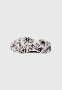 Shoe sole featuring a patterned design in shades of beige, black, and gray, with black studs and raised circular grips for traction.