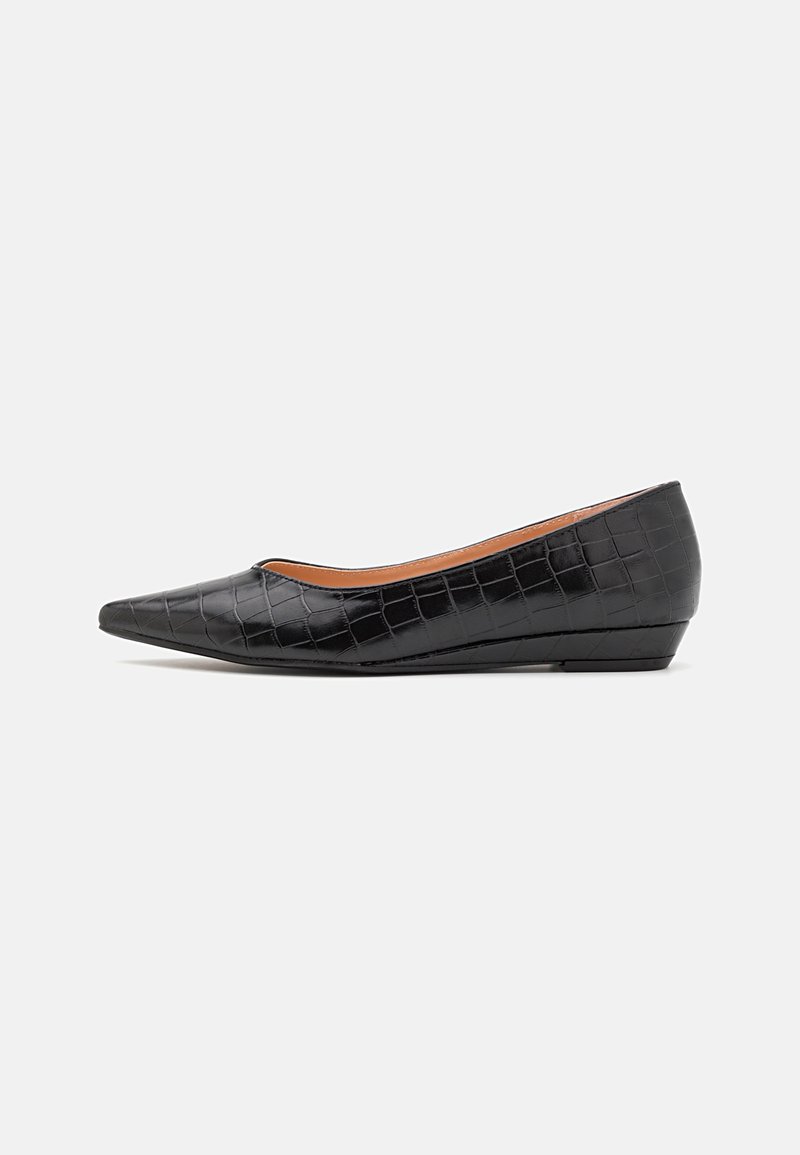 Chaussure compensée pour femme à bout pointu noire avec texture crocodile et talon bas, vue de profil sur fond blanc.
