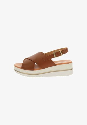 Sandalo in pelle marrone con cinturini incrociati, fibbia dorata regolabile, soletta imbottita e suola platform bianca con battistrada antiscivolo.