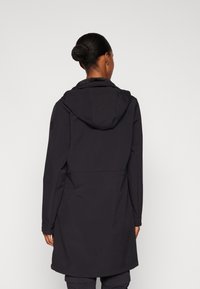 Manteau noir à capuche avec une texture lisse et une coupe ajustée. Doté d'une fermeture éclair dissimulée et de poches latérales pour plus de fonctionnalité.