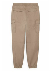 Pantalon cargo beige avec taille et poignets élastiques, comprenant deux poches à rabat à l'arrière et deux poches cargo sur les côtés.