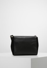 Borsa in pelle nera con una texture liscia, forma rettangolare, patta superiore e tracolla regolabile. Presenta dettagli in oro minimalisti.