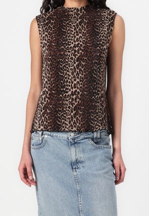 Mouwloze bruin-zwarte luipaardprint blouse met plooien, gedragen met lichtblauwe denimrok, zichtbaar van schouders tot heupen.