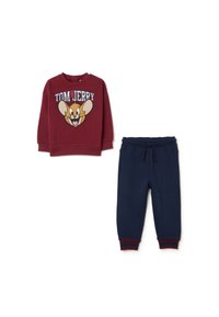 Roter Pullover mit einem Tom und Jerry Motiv, kombiniert mit marineblauen Jogginghosen mit elastischem Bund und roten gestreiften Bündchen.