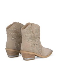 Stivaletti in suede beige con design a taglio, dettagli in borchie e tacco impilato con una striscia argentata alla base.