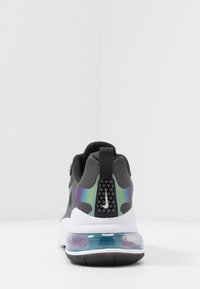Černá sportovní bota s měkkým svrškem, iridescentními akcenty a průhlednou vzduchovou jednotkou v patě. Obsahuje texturovaný poutko na patě.