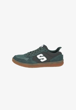 Zapatilla baja de color verde oscuro con paneles de ante y cuero, logo blanco "S" en el lateral, suela de goma translúcida marrón y cordones negros.