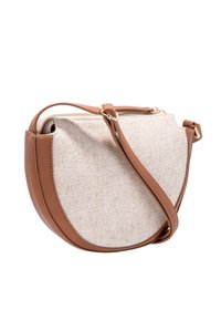 Hnědo-červená kožená crossbody taška z béžové tkaniny zaobleného tvaru, se zipovým uzavřením a nastavitelným popruhem. Strukturovaný materiál kontrastuje s hladkou kůží.