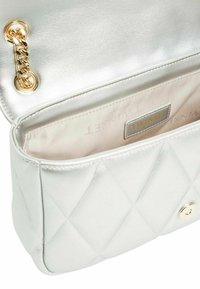 Borsa in pelle argentata trapuntata con accentuazione in catena dorata. L'interno presenta una fodera beige e un'etichetta TWINSSET. Forma compatta rettangolare.