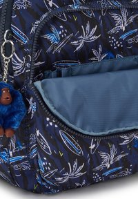 Zaino in tessuto blu navy con motivo floreale, dotato di un portachiavi a forma di gorilla in peluche e di una tasca frontale liscia e priva di decorazioni.