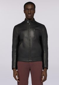 Černá kožená bunda s vysokým límcem, předním zipovým uzávěrem a bočními kapsami. Má elegantní design a hladkou texturu.