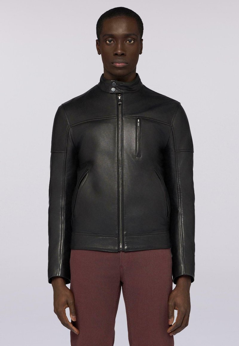 Černá kožená bunda s vysokým límcem, předním zipovým uzávěrem a bočními kapsami. Má elegantní design a hladkou texturu.