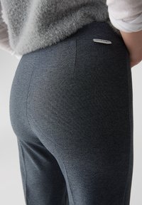Grijze, gemarmerde legging gemaakt van rekbaar materiaal, met een logo-label op de tailleband en een aansluitende pasvorm.