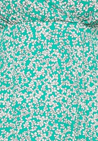 Tiefgrünes Blumenkleid mit einem dichten Muster aus kleinen weißen Blumen mit dunkelblauen Mittelpunkten; leichtes Material mit glatter Textur.