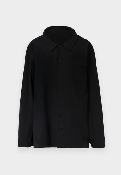 Cămașă neagră cu mânecă lungă, cu nasturi, guler și buzunar pe piept, expusă plat pe un fundal alb.