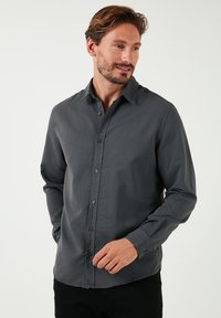Halllong-sleeve shirt, hallgray, nöpitsiga disainiga, valmistatud kergest materjalist, millel on sile tekstuur ja klassikaline krae.