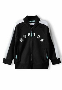 Veste zippée noire avec des accents blancs aux épaules, dotée d'un logo rond, de poches latérales avec des tirettes de fermeture éclair bleues et de poignets côtelés. Tissu doux.