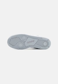 Saucony sneaker sole in light grey rubber; features textured tread with circular patterns and branding engraved on the midsection.