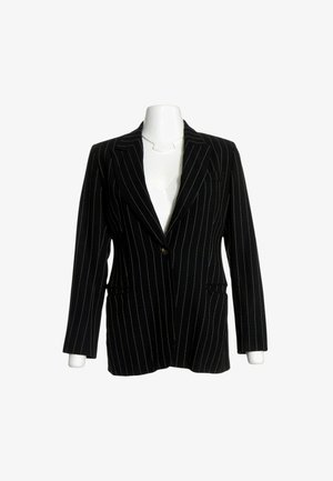 Blazer negro de un solo botón con rayas verticales blancas, mostrado en un torso de maniquí blanco sobre un fondo blanco.