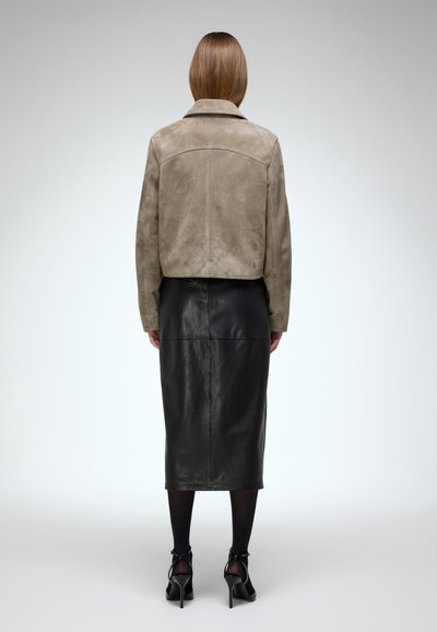 Suede taupe jacket with a collar, paired with a black leather midi skirt, featuring a smooth texture and a fitted silhouette.