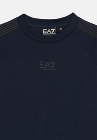 Marineblaues Kurzarmhemd aus weichem Stoff, mit einem dezenten EA7-Logo in der Mitte und gestreiften Akzenten auf den Schultern.