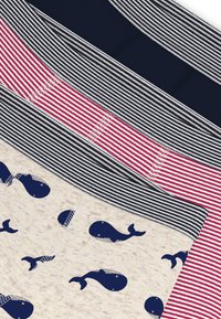 Mint gyűjtemény különböző mintájú anyagokból: tengerészkék egyszínű, piros csíkos, szürke csíkos, és bézs-kék bálnamintás. Puha textúrák és változatos tervezés.