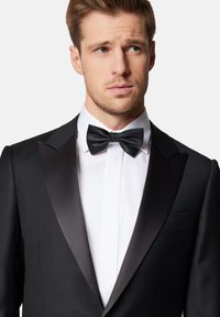 Czarny frak z satynowymi klapami, w zestawieniu z białą koszulą i teksturowanym czarnym muszką. Gładka faktura materiału i dopasowany krój.