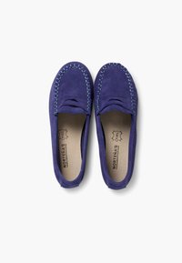 Lilla ruskind slip-on sko med kontrasterende lyseblå stikninger langs kanterne, med en rund tå og blød indvendig foring.