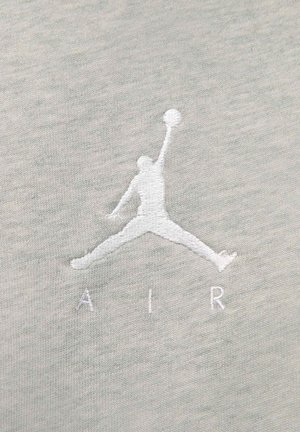 Tela gris clara con un logotipo blanco bordado prominente de una figura saltando con la palabra "AIR" debajo.