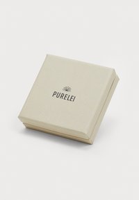 Jewelbox Purelei, štvorcový tvar, svetlo béžový papier s reliéfnym vzorom listov, logo vytlačené tmavým písmom na vrchu, minimalistický dizajn.