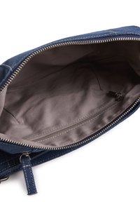 Borsa a pochette in denim con interno liscio, chiusura con zip e una piccola tasca interna. Esterno blu scuro con dettagli di cucitura a contrasto.