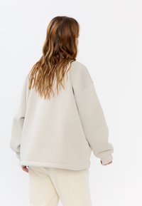 Overmatige lichtgrijze sweatshirt, gemaakt van zachte stof, met verlaagde schouders, ribgebreide manchetten en een ronde zoom.