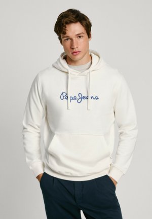 Felpa bianca realizzata in morbido tessuto, con logo "Pepe Jeans" ricamato in blu sul petto e tasca frontale. Abbinata a pantaloni blu navy.