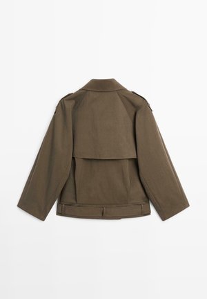 Brown, structured jacket with a detachable back panel, wide sleeves, and epaulet accents. Made from a textured fabric, featuring a belted waist.