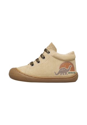 Scarpe per bambini in suede beige con suola in gomma marrone, dotate di design di dinosauri verde e arancione e lacci marroni laterali.