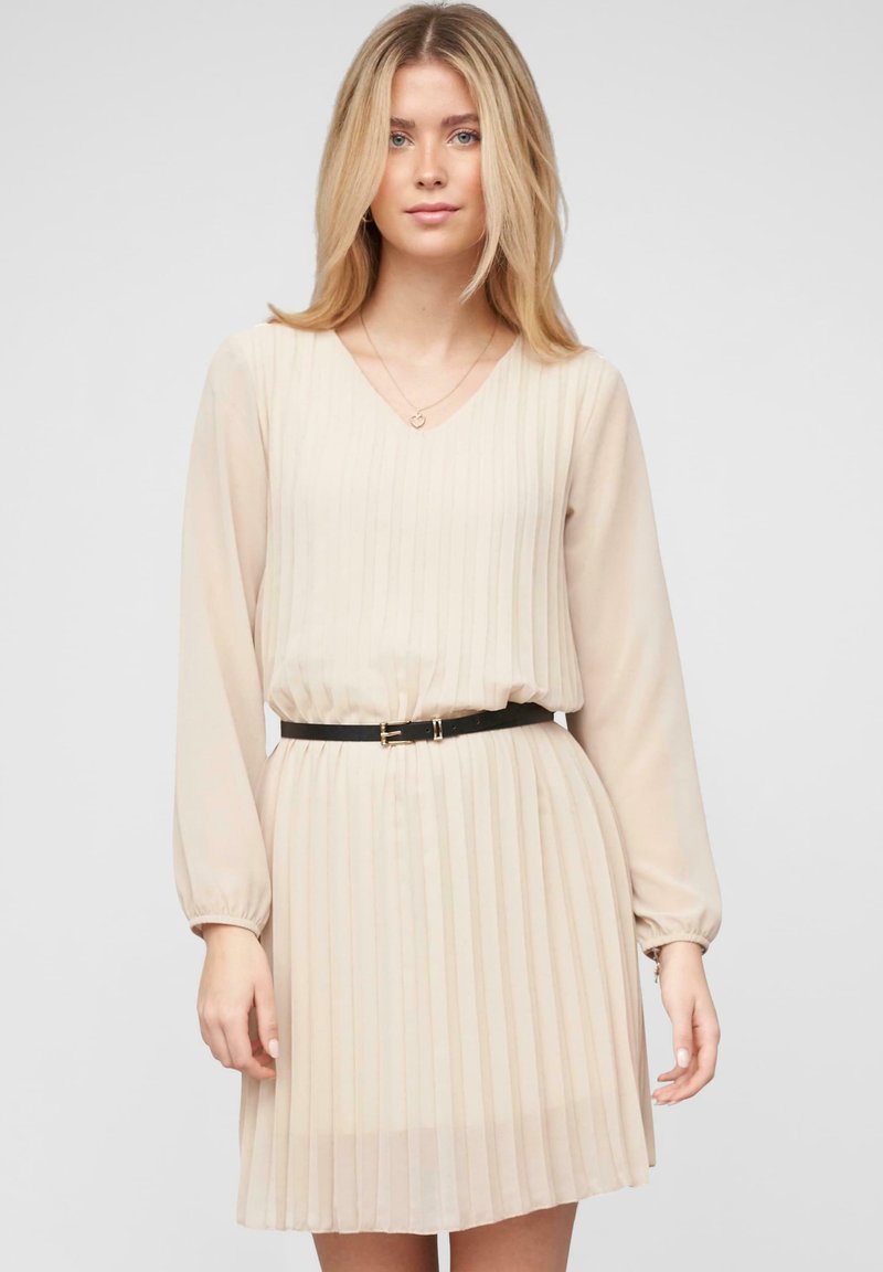 Beige geplooide jurk met lange mouwen, V-hals, taillering, zwarte riem met gouden hardware, lichtgewicht stof en een vloeiende rok.