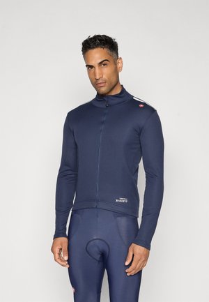Marineblaue Fahrradjacke mit langen Ärmeln, Reißverschluss und hohem Kragen. Mit einem Logo auf der Schulter und taillierter Passform.