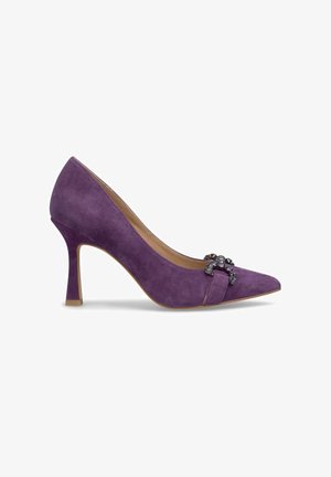 Chaussure à talon haut en daim violet avec un bout pointu, ornée d'un nœud décoratif et de bijou à l'avant, et d'un talon fin.