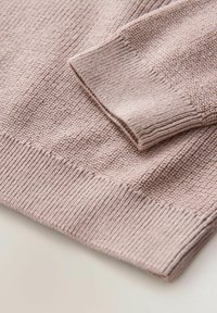 Jasnoróżowy sweter z dzianiny o fakturowanej powierzchni z prążkowanymi mankietami i dołem, podkreślający miękki materiał i dopasowany krój.