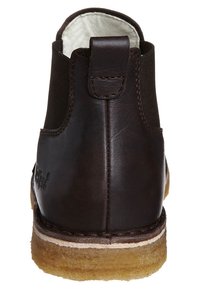 Brązowy skórzany botek za kostkę z gładkim wykończeniem, zaokrąglonym noskiem i przeszyciami. Posiada pętlę do ściągania z tyłu oraz naturalną gumową podeszwę.